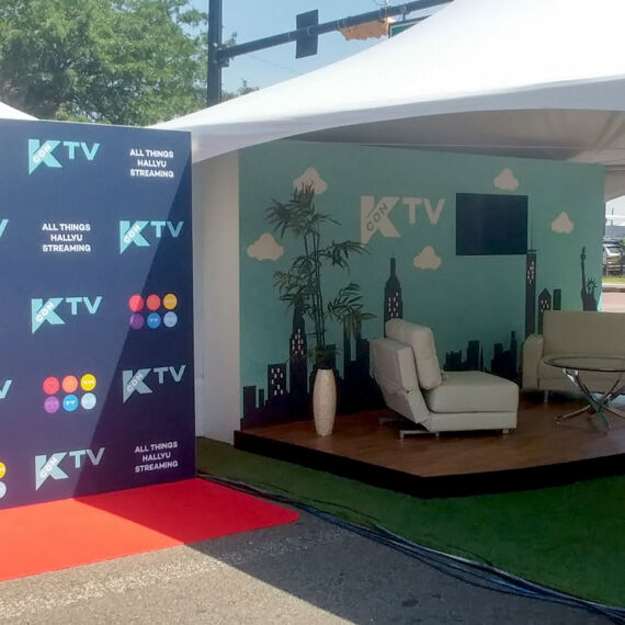 Outdoor TV set stage for Kcon inside tent with graphic wall for intros