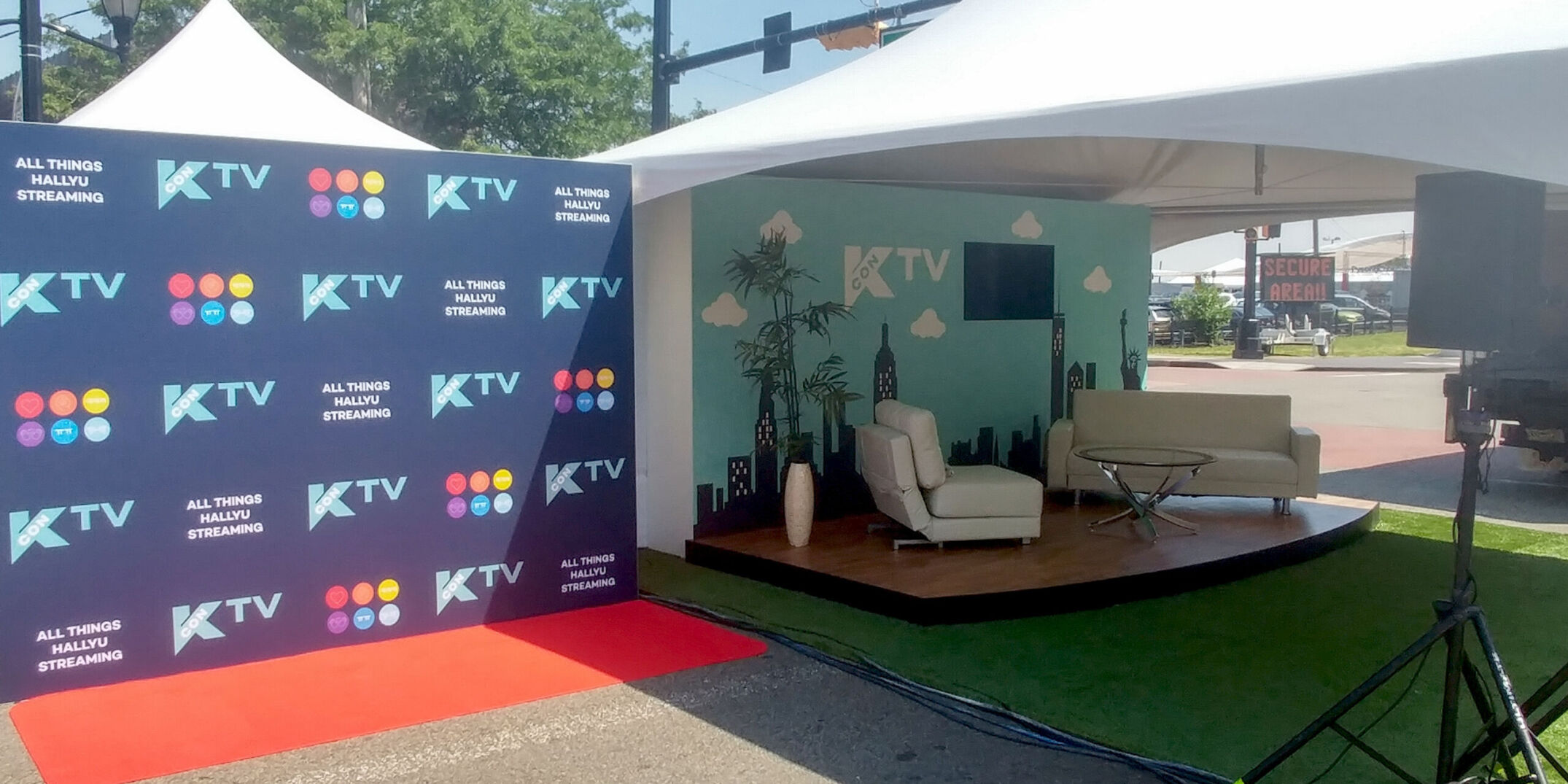 Outdoor TV set stage for Kcon inside tent with graphic wall for intros