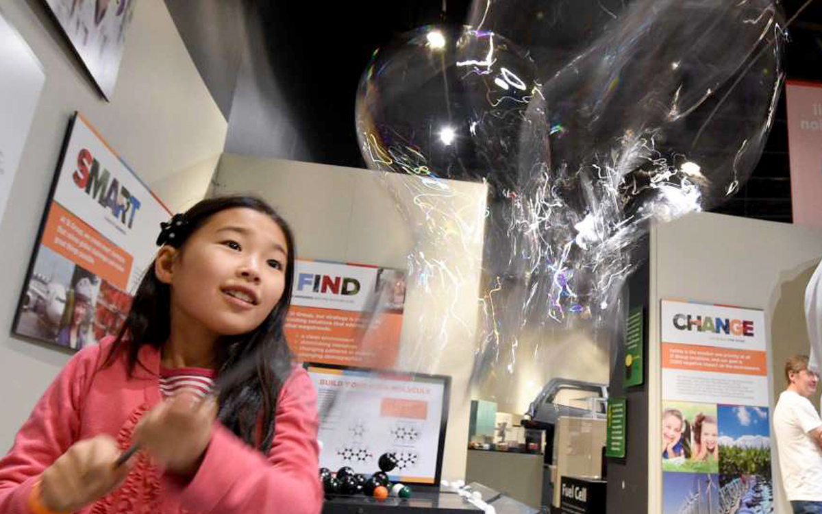 Girl playing with bubbles in custom interactive display at MISCI