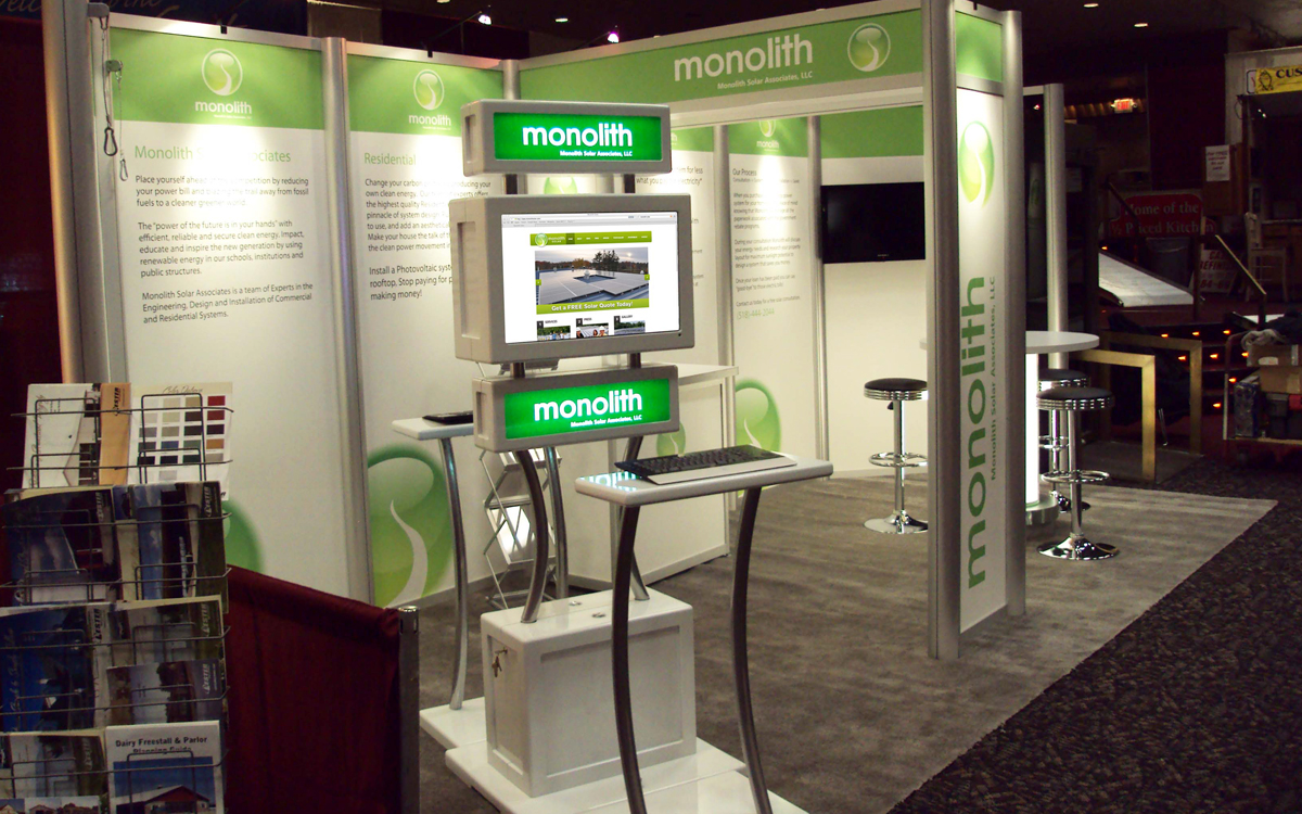 10' x 20' trade show booth for Monolith Solar with custom kiosk and backlit bistro table