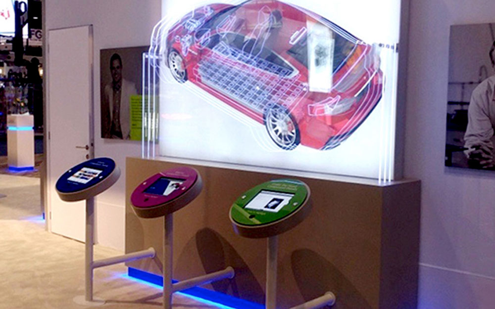 Empire exhibits custom interactive kiosk with LED lit car graphic. Different areas of the car light up with glowing outline with use of the monitor kiosks