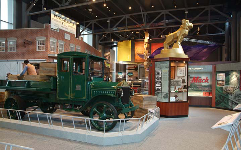 Custom built storefront, display cases, turntable with statue and rails around museum displays for America on Wheels