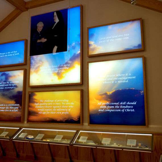 lightbox graphic wall panels and hanging scrim graphic with custom lighted display cases holding artifacts