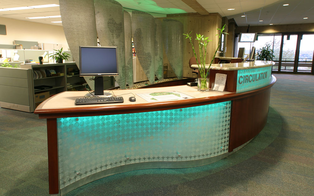 Custom built desk with backlights and sail room dividers with teal lights in the Folsom Library at RPI