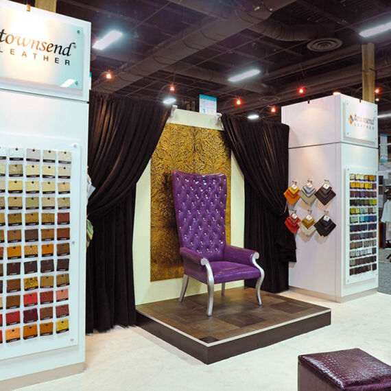 Trade show exhibit booth with purple chair display, stem lighting and sample racks for Townsend Leather